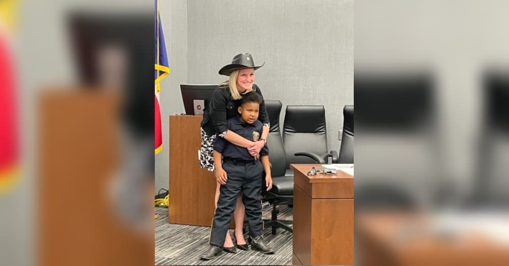 DJ shared his hat as he took photos with the ESD 9 commissioners at the March 24 meeting. (Mikah Boyd/Community Impact Newspaper)
