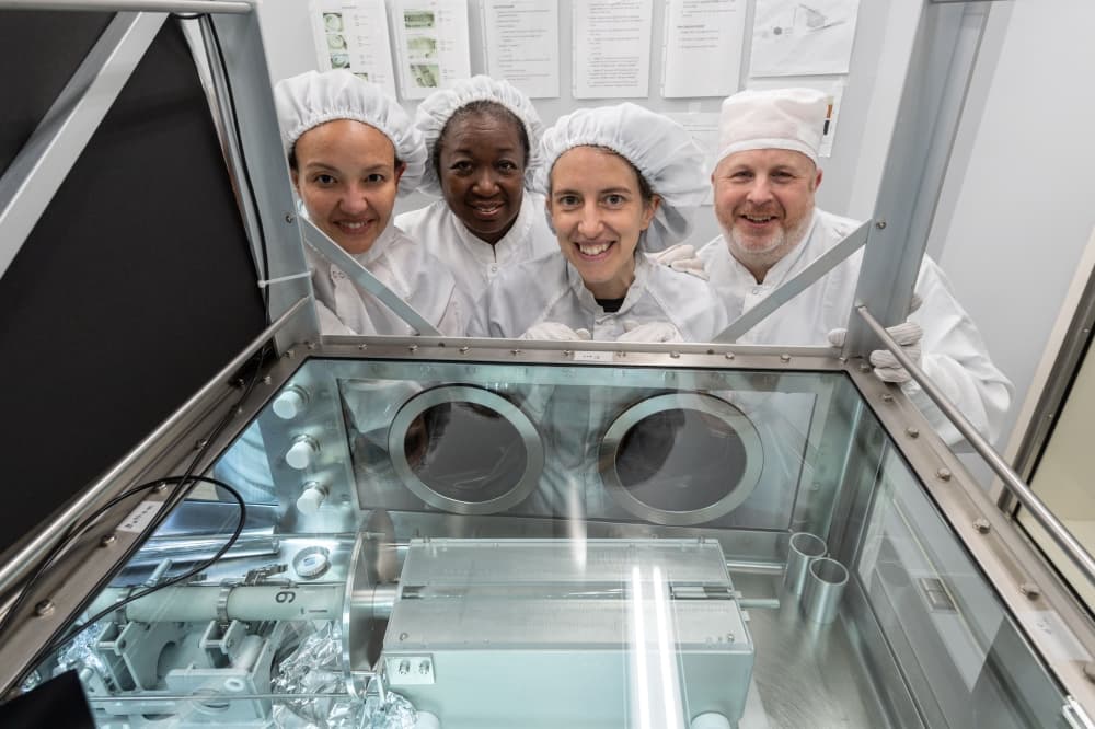 The Apollo 17 sample 73001 processing team stands in front of the newly opened sample at NASA’s Johnson Space Center in Houston. The team includes (from left) Charis Krysher, Andrea Mosie, Juliane Gross and Ryan Zeigler. (Courtesy Robert Markowitz/NASA)