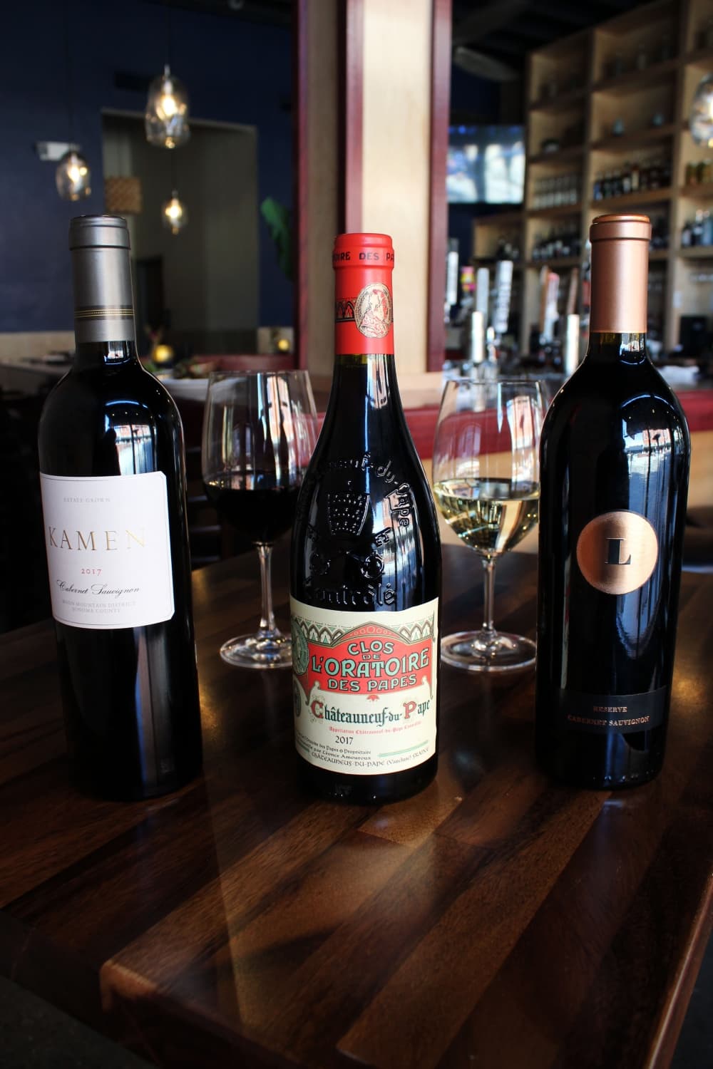 Urban Grill & Wine Bar carries boutique wines that are difficult to find locally and represent 50 grape varietals. From left are Kamen 2017, Clos De L’Oratoire Des Papes and Lewis. Prices range from $44-$275 per bottle. (Karen Chaney/Community Impact Newspaper)
