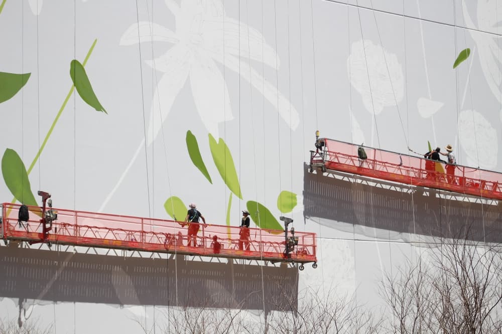 Fourteen people are painting the mural at Waterway Square. (Andrew Christman/Community Impact Newspaper)