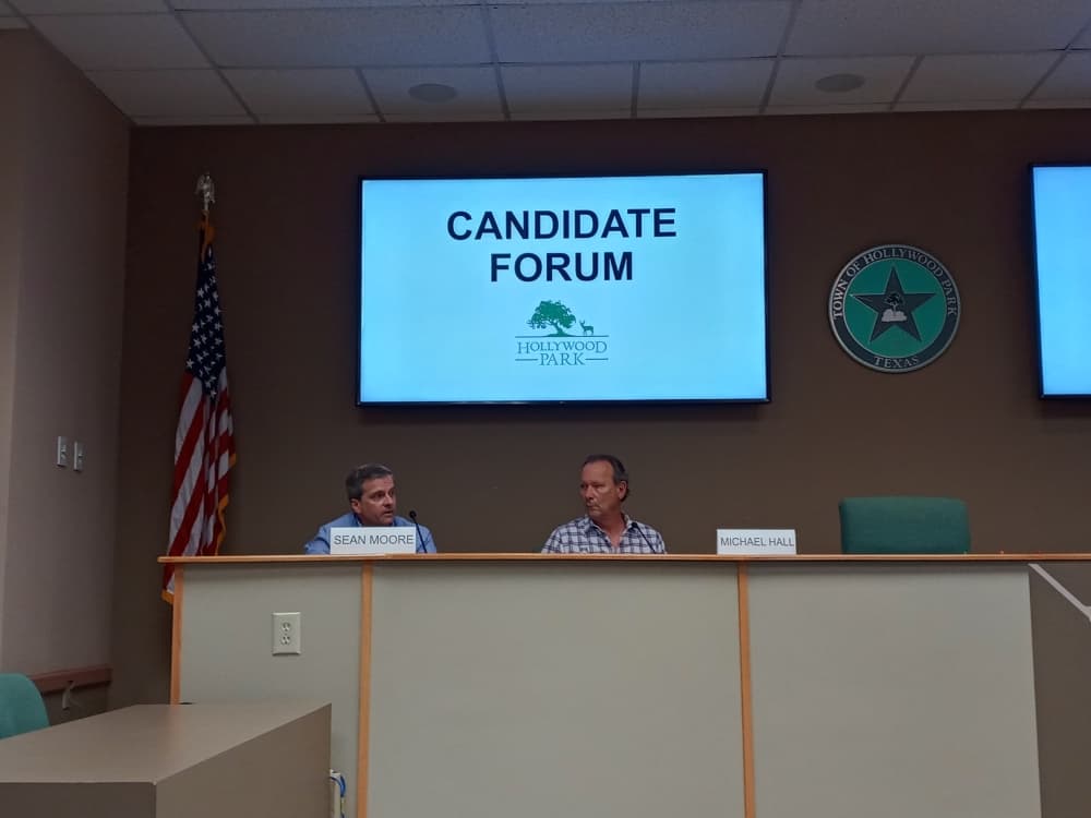 Hollywood Park mayoral candidate and current Place 1 City Council Member Sean Moore (left) speaks as council Place 2 contestant Michael Hall listens during an April 4 Hollywood Park candidate forum at City Hall. (Edmond Ortiz/Community Impact Newspaper)