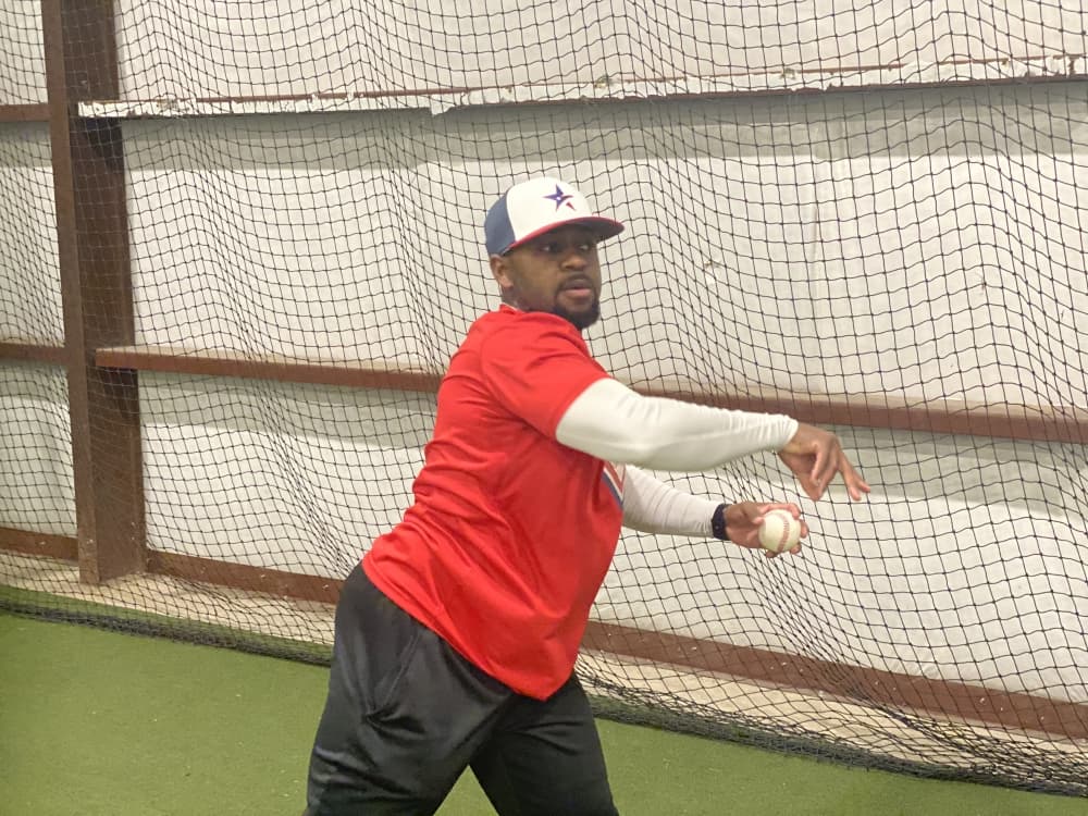 
Coach Joshua Colvin works with players during batting practice.