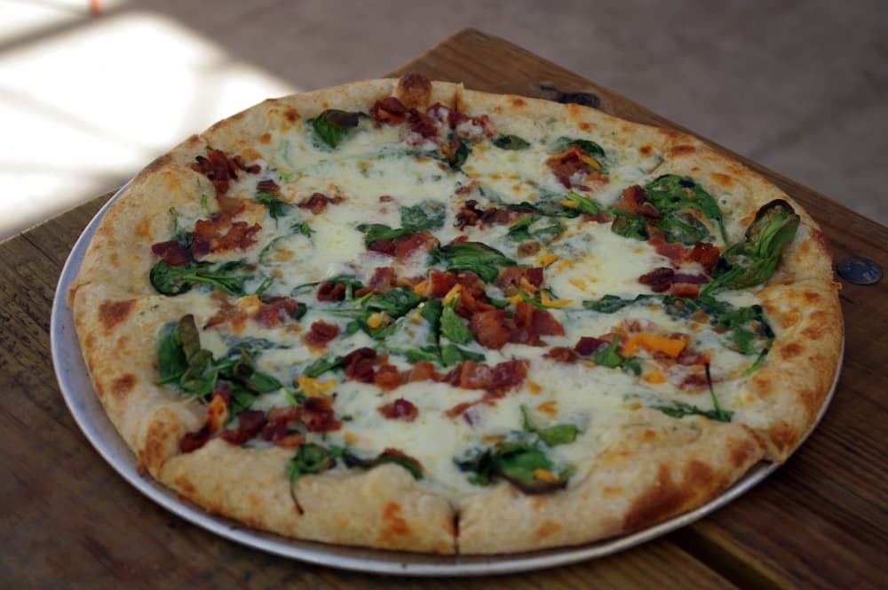 
Angry Bee ($17): This pizza has a house Alfredo sauce, spinach, shaved habanero, hot glitter honey drizzle and edible flower.