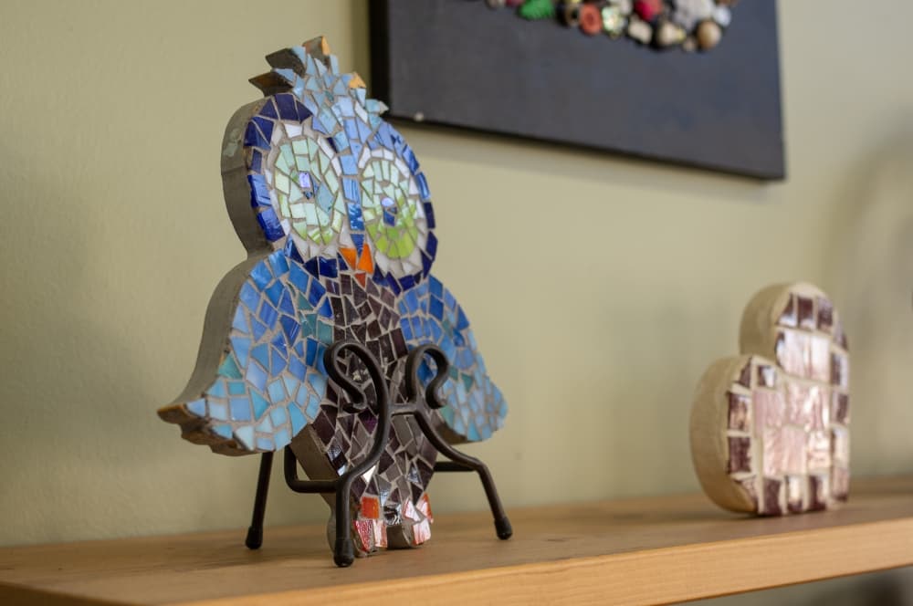 Mosaic pieces are glued to wooden boards and grouted at home. (Warren Brown/Community Impact Newspaper)