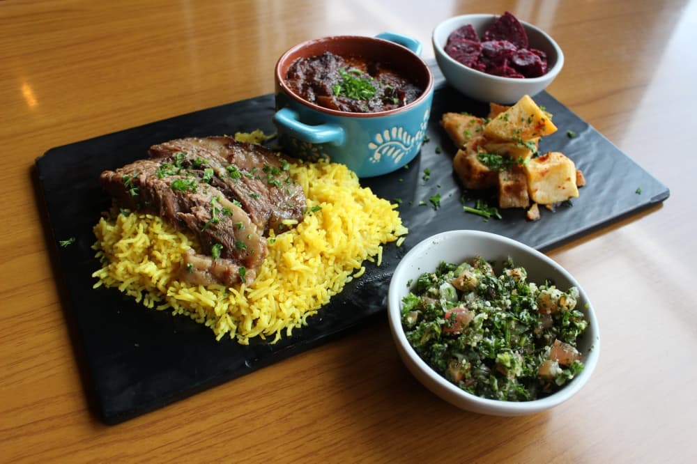 Plates at Ta'Bleyah can be made up of brisket, yellow rice, beet salad and potatoes. (Andrew Christman/Community Impact Newspaper)