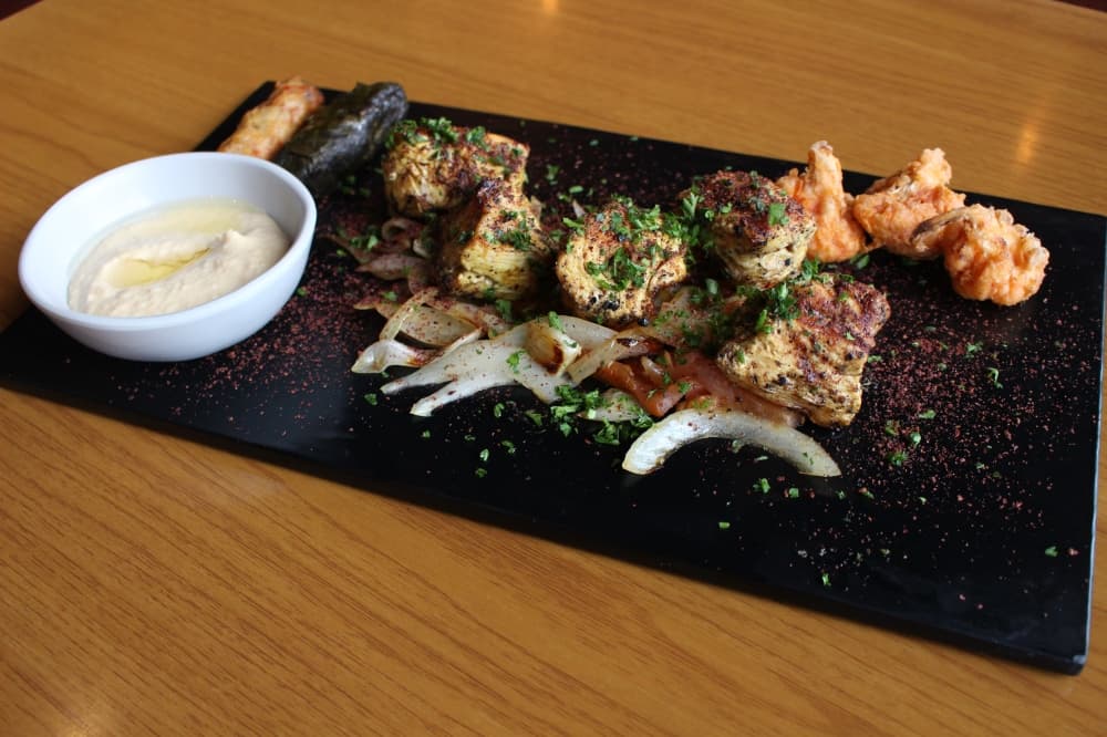 Options at Ta'Bleyah include hummus, grilled chicken, grilled vegetables and fried cauliflower. (Andrew Christman/Community Impact Newspaper)