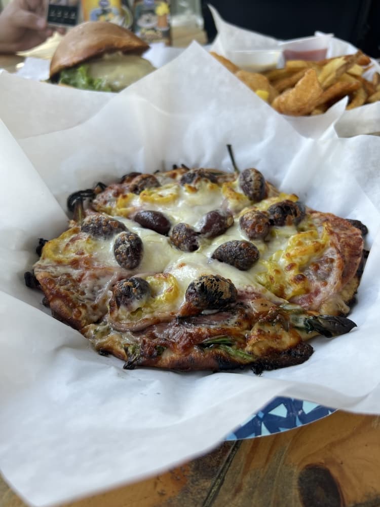 Bianca Pizza ($11 for 8-inch) features chevre cheese, salami, Kalamata olives, red onion, spinach and banana peppers over a garlic and herb sauce. (Maegan Kirby/Community Impact Newspaper)