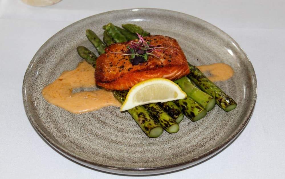 One of Stone House Restaurant’s fan-favorite dishes is its seared salmon with asparagus and smoked tomato butter. (Bailey Lewis/Community Impact Newspaper)