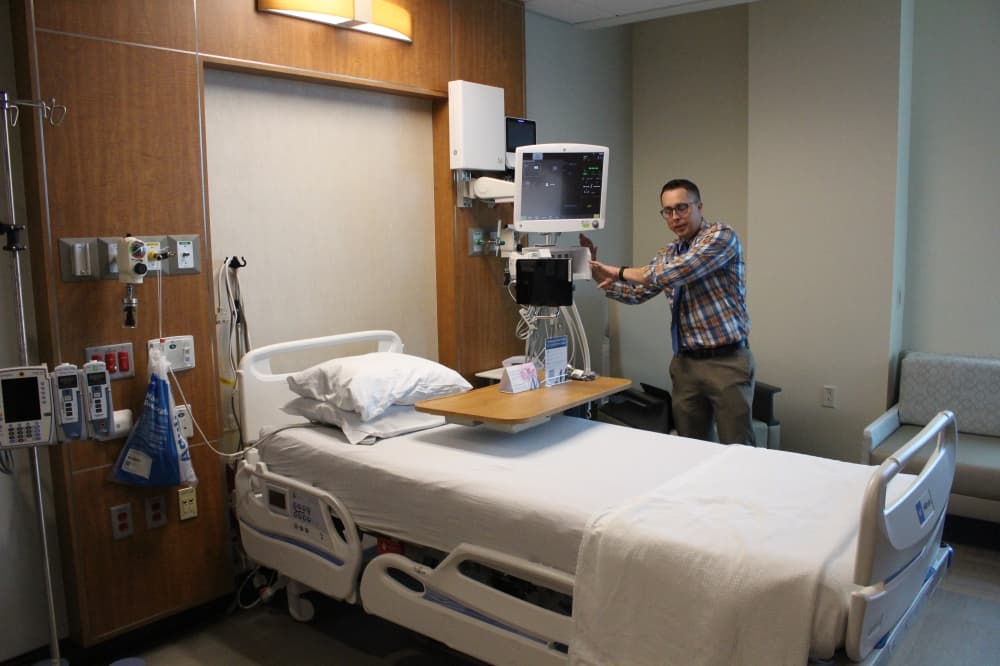 Nathan Way, director of acute care, showed how devices give patients access to services, such as ordering food. (Andrew Christman/Community Impact Newspaper)