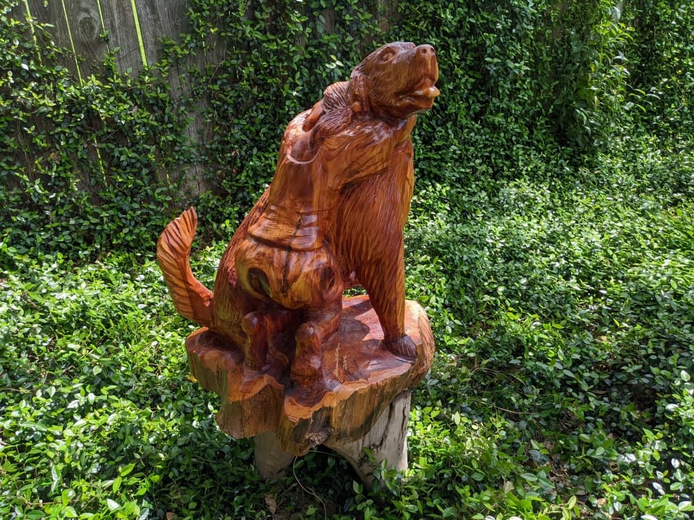 Phillips enjoys carving animals, such as this dog being hugged by a child. (Jake Magee/Community Impact Newspaper)
