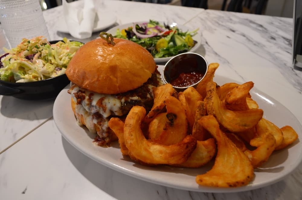 The southern comfort burger ($17) is gold ring wagyu beef dressed with crispy jalapenos, sweet and spicy peaches, applewood bacon jam and bleu cheese fondue. (Hunter Terrell/Community Impact Newspaper)