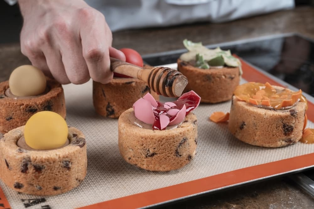 The pop on top of the cake base is cracked open using a utensil. (Courtesy FoliePop's)