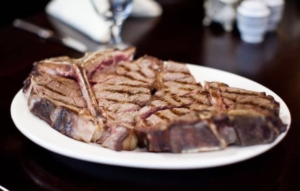 The T-bone steak ($47.95) is cooked to order and served on a dish heated to 500 degrees. (Courtesy Bistro Italiano and Rex Steakhouse)