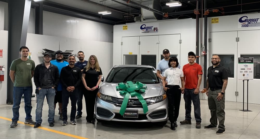 people pose with sailor and vehicle