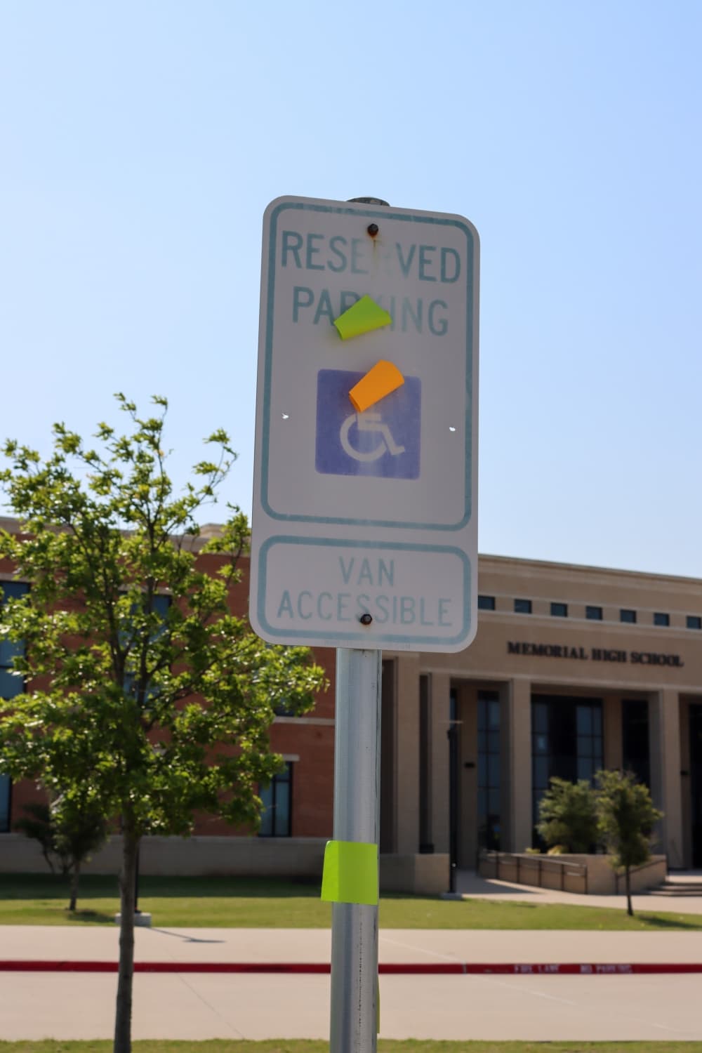 Sticky notes are placed on handicap parking sign outside of Memorial High School. The notes are a part of the originally planned and approved senior prank placing the notes on school property. (Grant Johnson/Community Impact Newspaper)