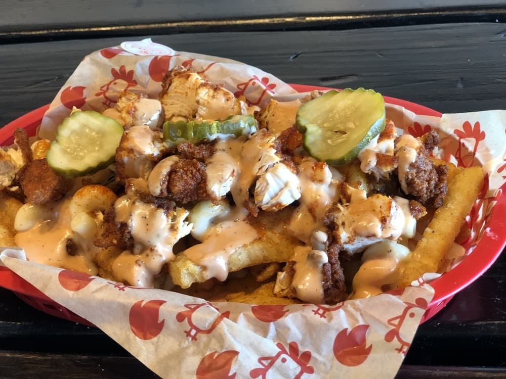 Urban Fries ($12) popularity is Owner Brandon Gawthorp's inspiration for the Chronic Fries virtual kitchen. The loaded fries basket is adorned with mac and cheese, chopped hot chicken tenders, bird sauce and pickles. (Asia Armour/ Community Impact Newspaper)