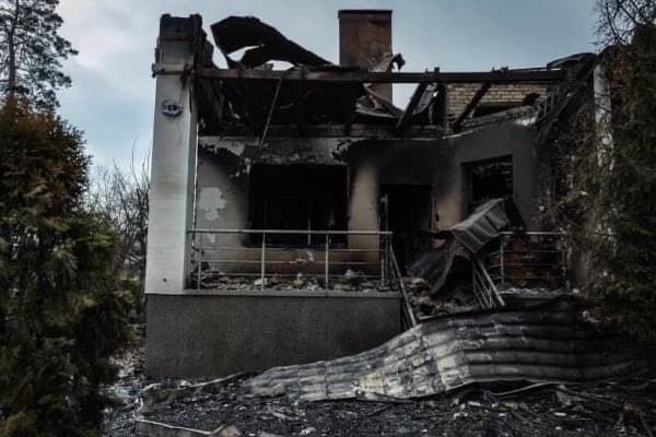 A bombed building is blackened and destroyed.