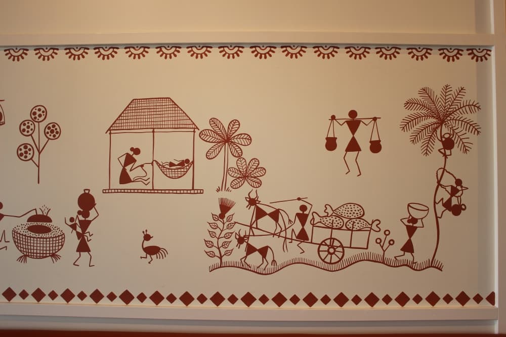 The art on Indian Kitchen’s walls is by local artist Uttara Patil. They depict the Warli tribe. (Brooklynn Cooper/Community Impact Newspaper)