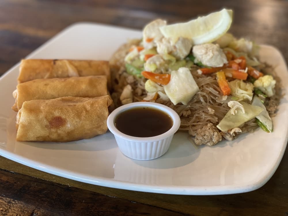 Pancit is Filipino noodles topped with mixed veggies, and the dish comes with three egg rolls.