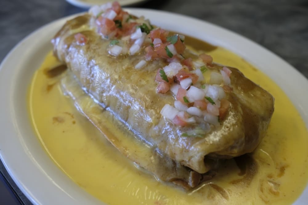 Chimichanga ($11.95): A burrito with choice of beef or chicken fajita is deep fried and topped with enchilada gravy, melted queso and pico de gallo. (George Wiebe/Community Impact Newspaper)