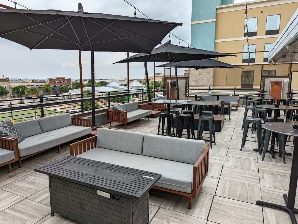 
Terrace features a rooftop patio and full bar with lounge seating and aerial views of Freiheit Village.
