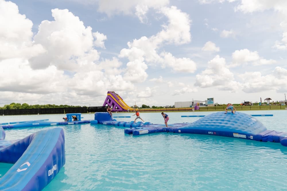 Kids at Lago Mar Lagoon play on the floating obstacle course. (Courtesy Lagoon Development Company)