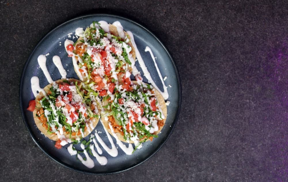 plate of tacos with white sauce drizzle