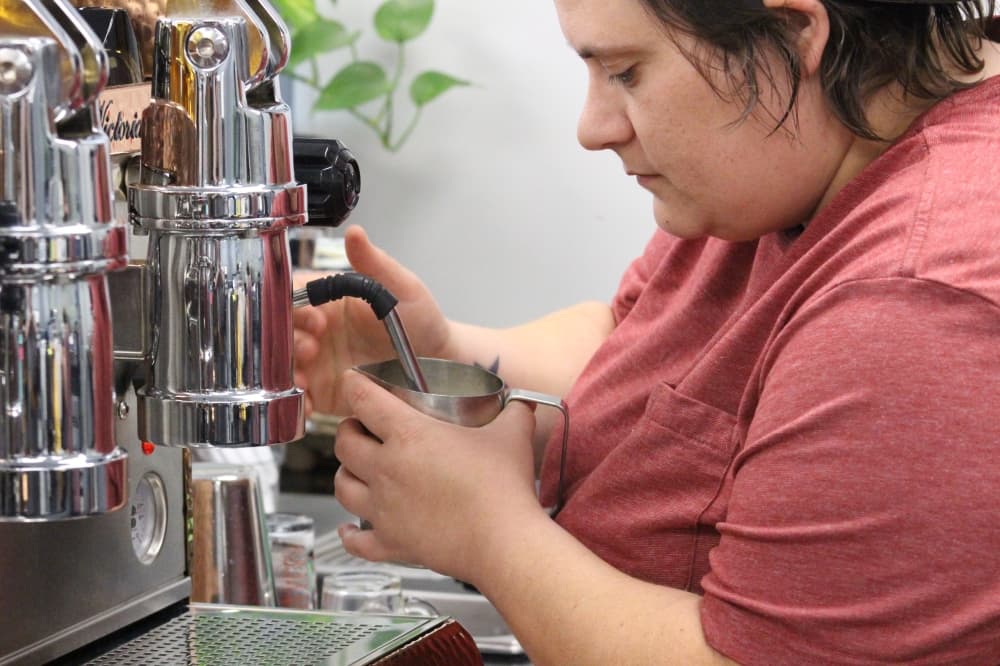 Conduit Coffee owner Christina Reece steams milk for a Call Me Old Fashioned latte. (Andrew Christman/Community Impact Newspaper)