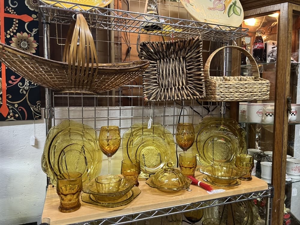 An indoor vendor sells plates, art and other home goods.