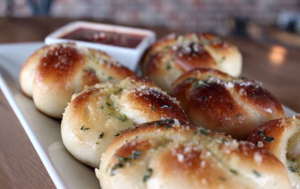 Garlic knots (Half-dozen $4.95) The knots consist of house-made dough, buttered and sprinkled with spices and served with freshly made marinara sauce. (Karen Chaney/Community Impact Newspaper)