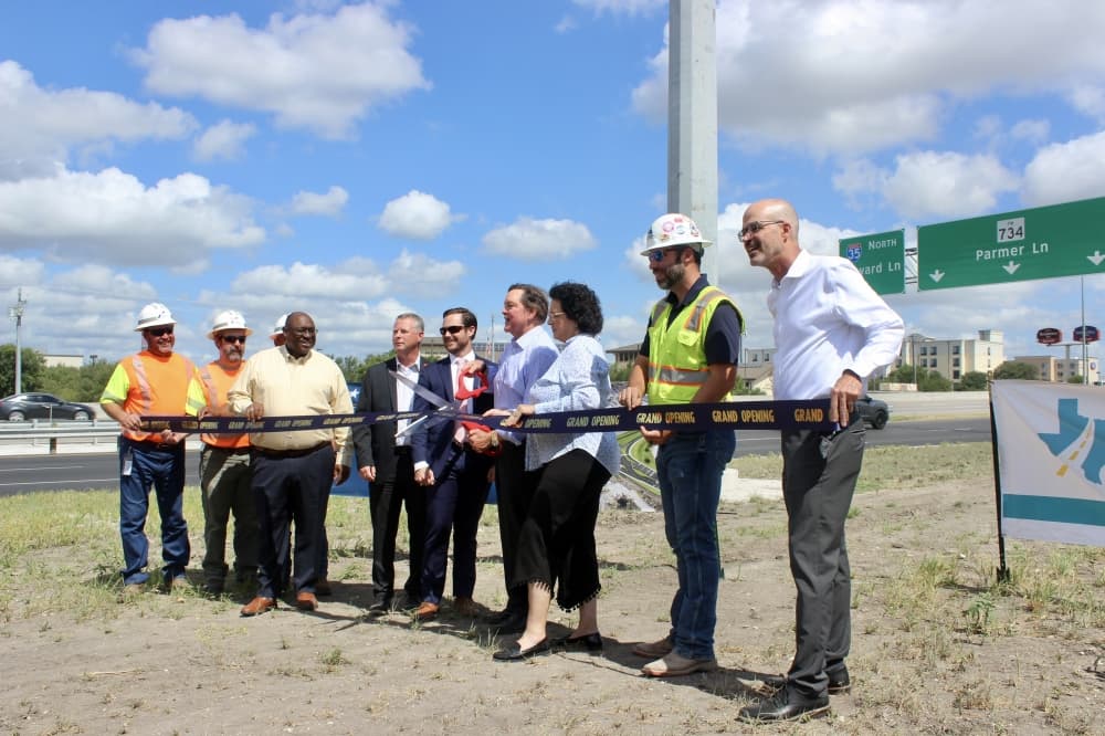 People cutting a ribbon on the side of a highway