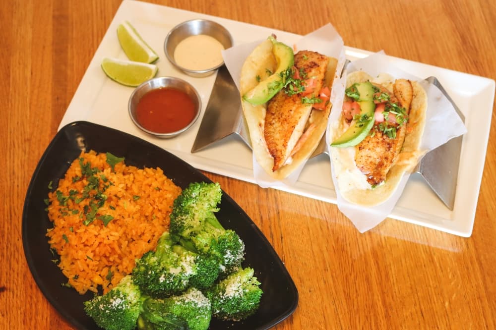 Jessica's Fish Tacos ($13.99) are made with grilled or blackened tilapia, cole slaw, avocado, pico de gallo and chipotle mayo on a corn tortilla and are served with cilantro lime rice and vegetables. (Grant Johnson/Community Impact Newspaper)