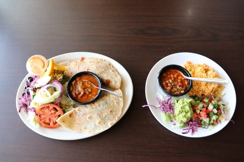 Two fish tacos are made with fresh fish and paired with beans, rice and pico de gallo. (Cynthia Zelaya/Community Impact)