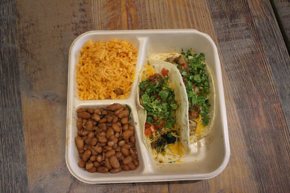 The two-taco plate ($8.50) is a platter of two tacos with a choice of meat and toppings, a side of beans and a side of rice. (Peyton MacKenzie/Community Impact Newspaper)