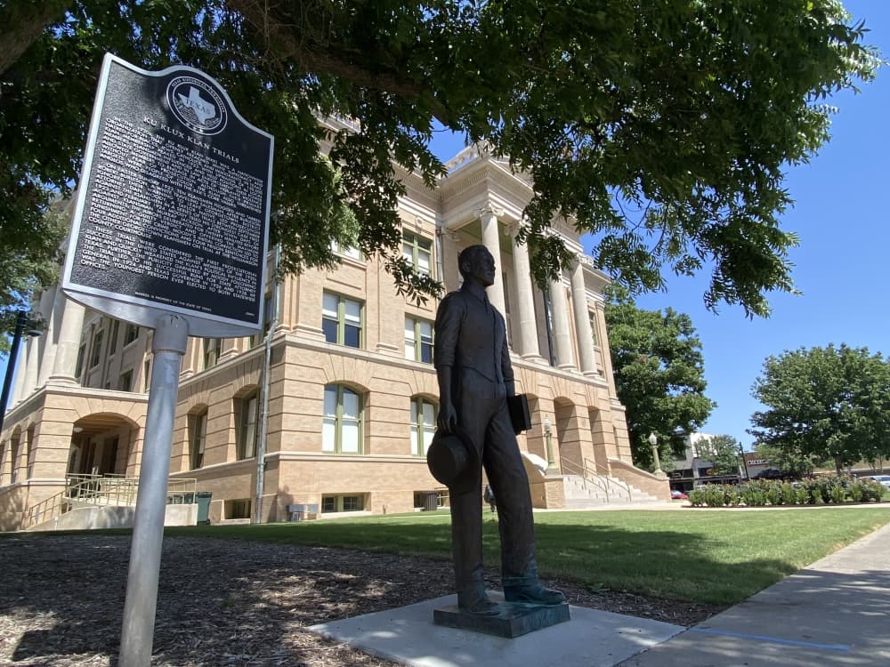 Building with a statue and plaque in front