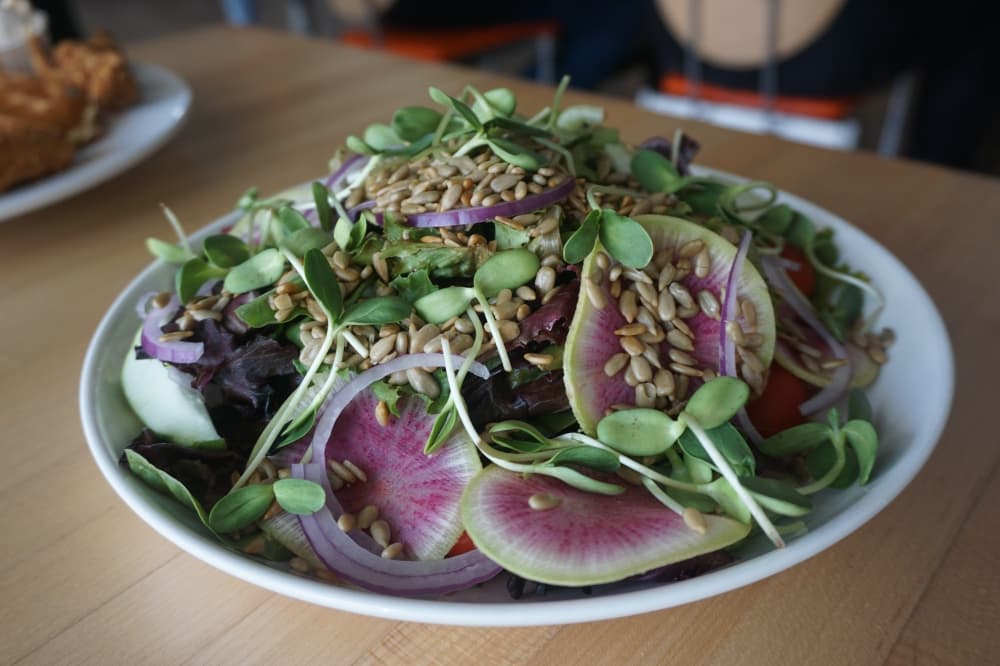 Sunflower crunch salad ($8)—Microgreens sourced from Henry’s Harvest are served with cabbage, romaine, cherry tomatoes, carrots, radish, red onion, sunflower seeds, tahini and lemon honey vinaigrette. (Mikah Boyd/Community Impact Newspaper)