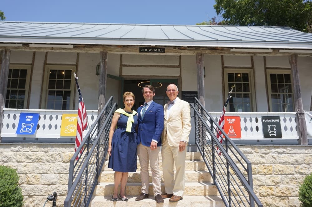 From left to right, Lark Mason, Erica Mason and Lark Mason III in front of the historic New Braunfels German farmstead building the family preserved by constructing their auction house. (Sierra Martin/Community Impact)