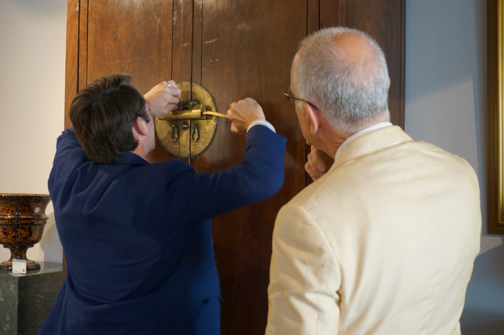 Lark Mason III and his father use a key to open a Chinese Cabinet from ca 1750 in the Lark Mason Gallery. (Sierra Martin/Community Impact Newspaper)