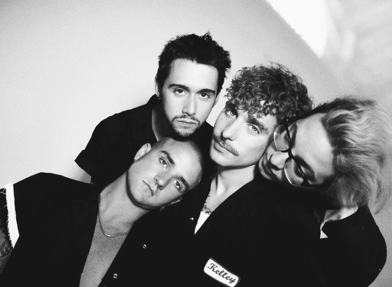 Three men and one woman posing for camera