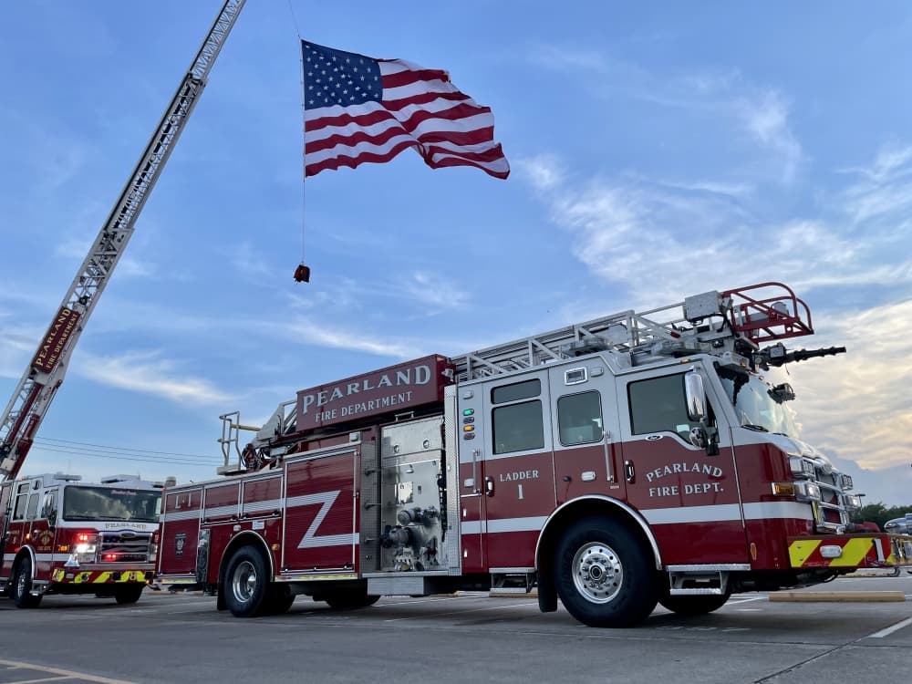 The Pearland Fire Department pulls out the United States flag to celebrate the Pearland All Stars. (Andy Yanez/Community Impact Newspaper)
