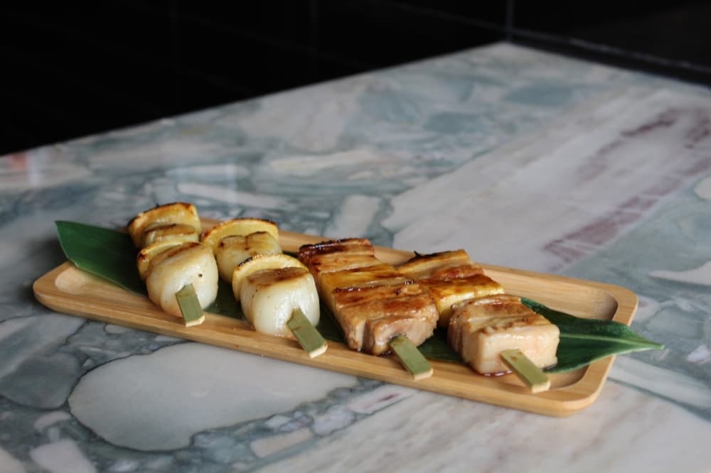 Skewers include Japanese sea scallops and pork belly with pineapple.