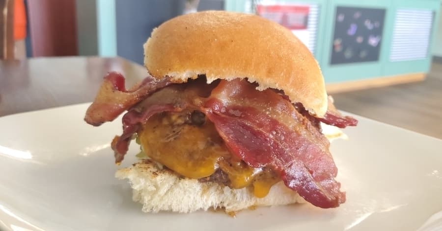 The bacon cheddar burger ($0.99) comes topped with bacon, cheddar cheese, pickles, lettuce, onion and tomatoes. (Jarrett Whitener/Community Impact Newspaper)