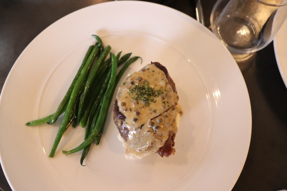 The filet mignon comes with green beans and mash potatoes. 