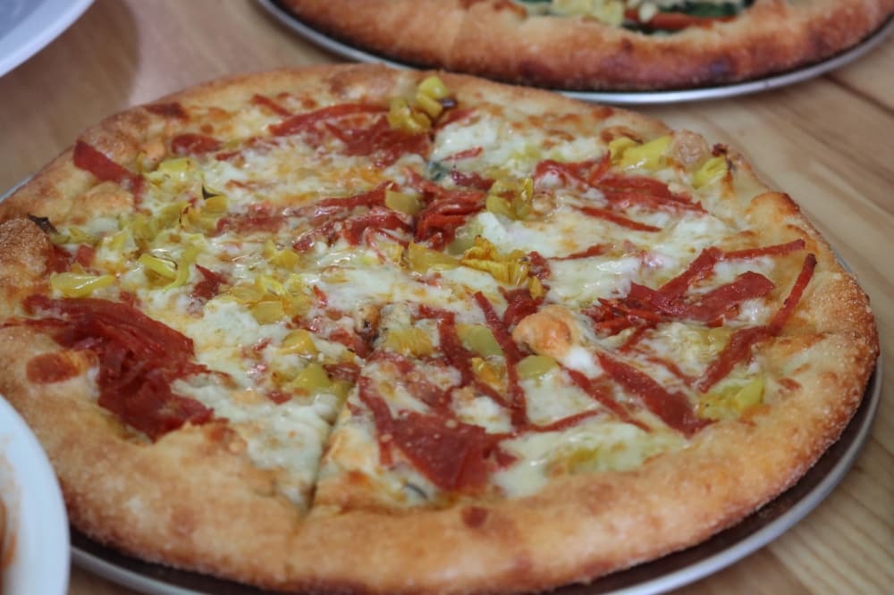 The DiGirolomo is topped with pepperoni, pepperoncini, gorgonzola and mozzarella. It is served as a 10-inch ($9.99) and 16-inch pizza ($22.49) or calzone ($13.99). (Grant Johnson/Community Impact Newspaper)