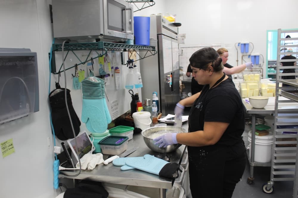 A Cookie Society employee preparing cookie ingredients in the kitchen.