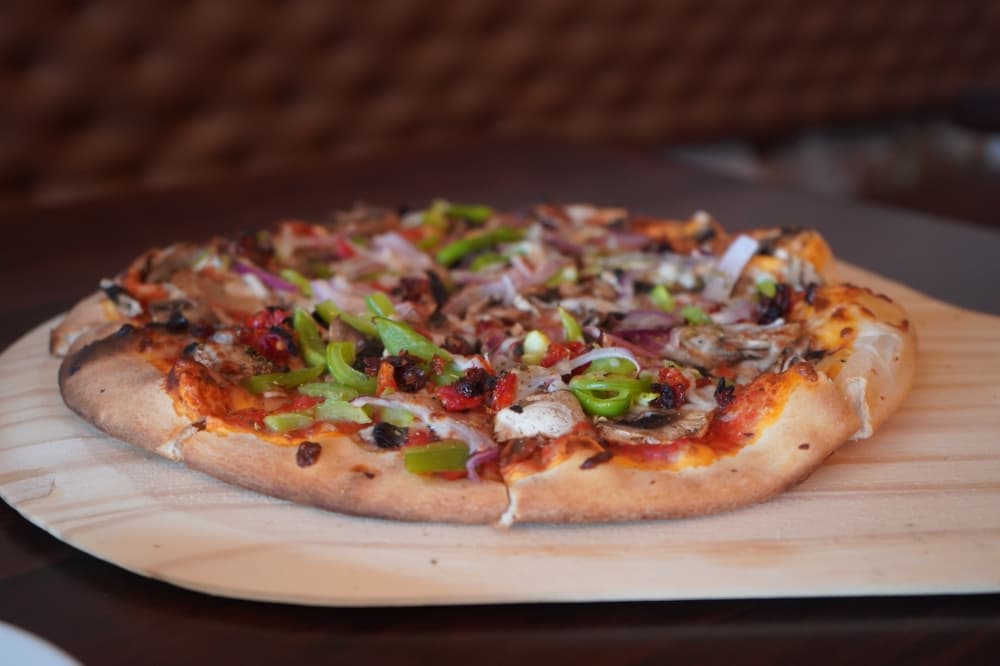Vegetariana pizza ($15) has red onions, tomatoes, bell peppers, mushrooms and black olives. (Christopher Goodwin/Community Impact Newspaper)