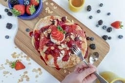 Aerial perspective on a platter of pancakes and fruit.