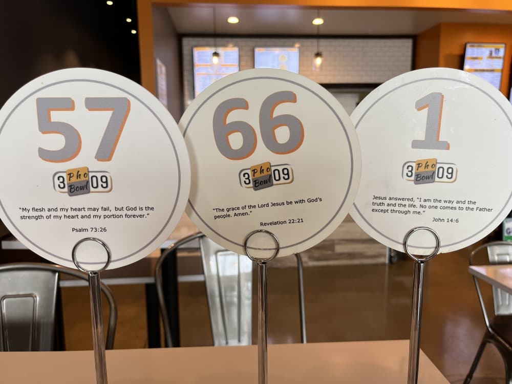 Table tents include scripture from the Bible at 3 Pho Bowl 09. (Tricia Schwennesen/Community Impact Newspaper)