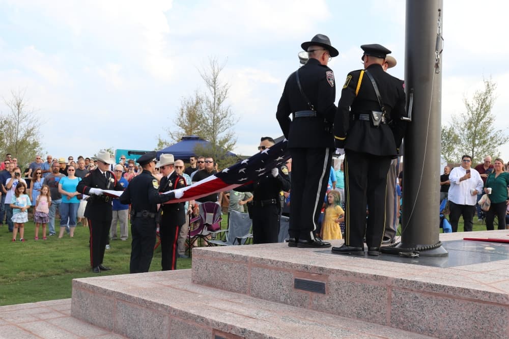 The raising of the flag ceremony was performed by Kyle and San Marcos police officers. (Zara Flores/Community Impact Newspaper)