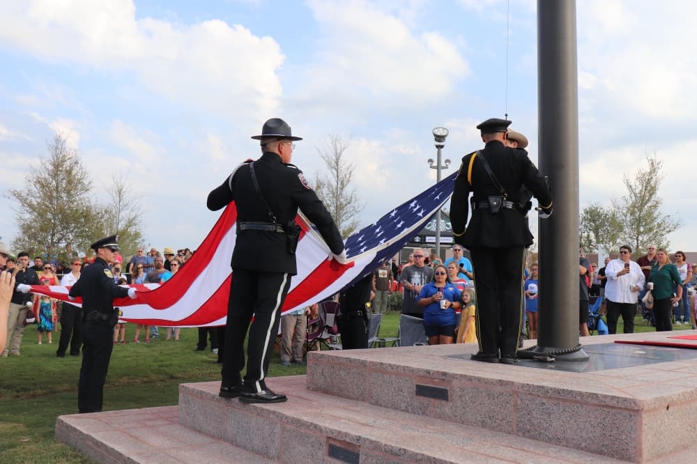 The raising of the flag ceremony was performed by Kyle and San Marcos police officers. (Zara Flores/Community Impact Newspaper)